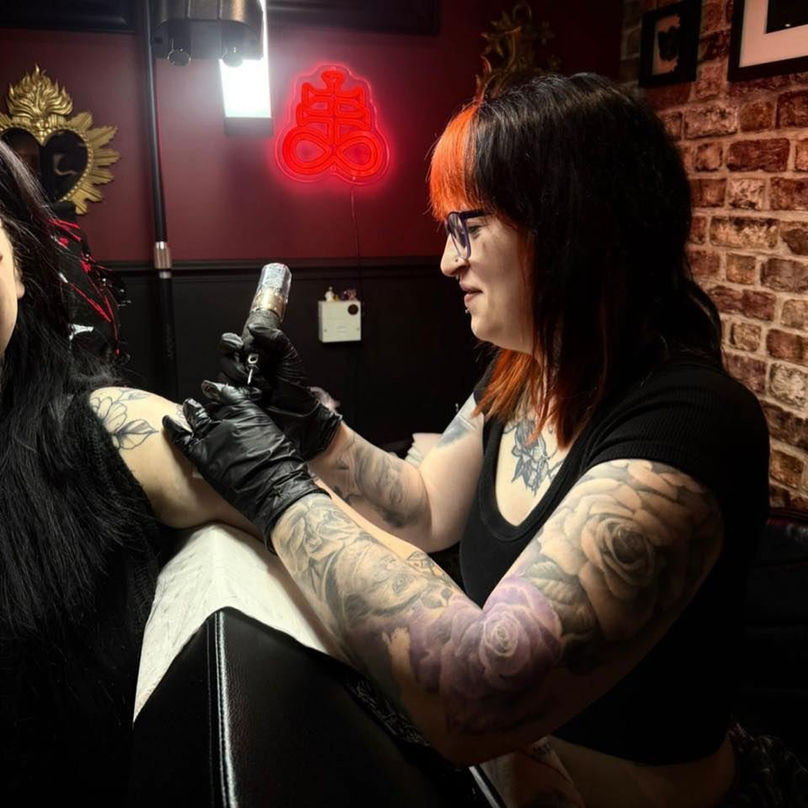 Abbie Fletcher tattooing a client